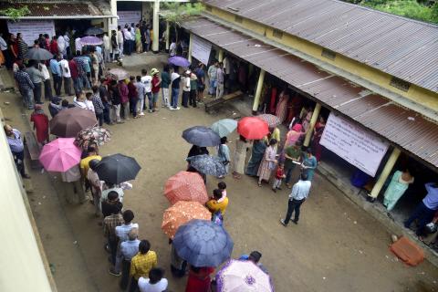 Voters taking cover from the sun while queuing to cast their vote in a polling station during the Indian elections in May 2024. Source: Photo by Dasarath Deka/ Shutterstock